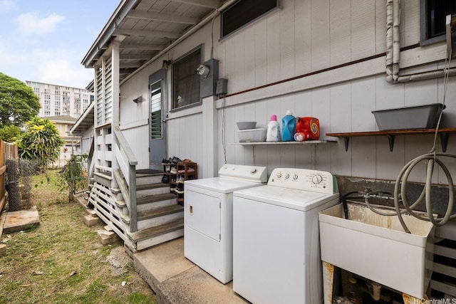 laundry area featuring washing machine and clothes dryer, laundry area, and a sink