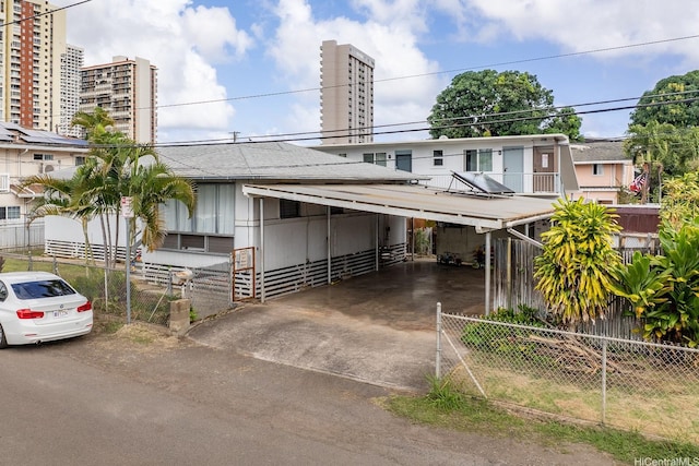 view of front facade featuring fence, driveway, and an attached carport