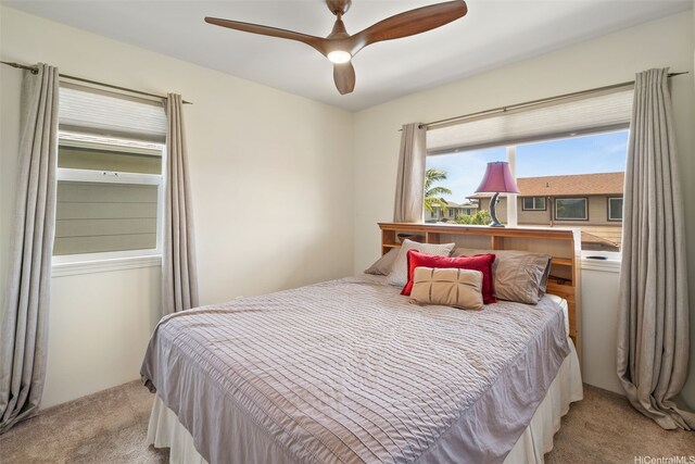 bedroom with light colored carpet and a ceiling fan