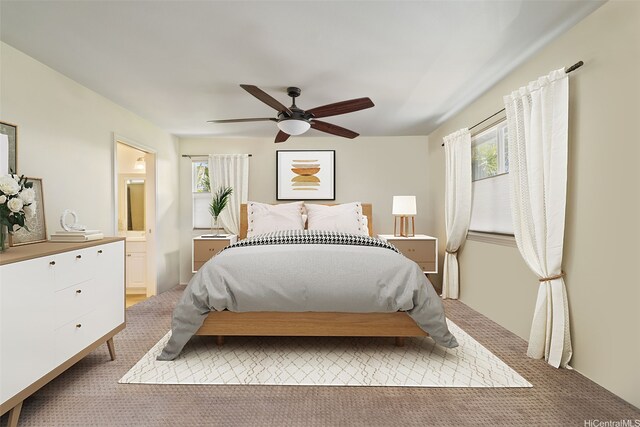carpeted bedroom with a ceiling fan and ensuite bath