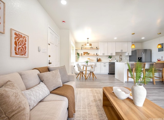 living area with light wood finished floors and recessed lighting