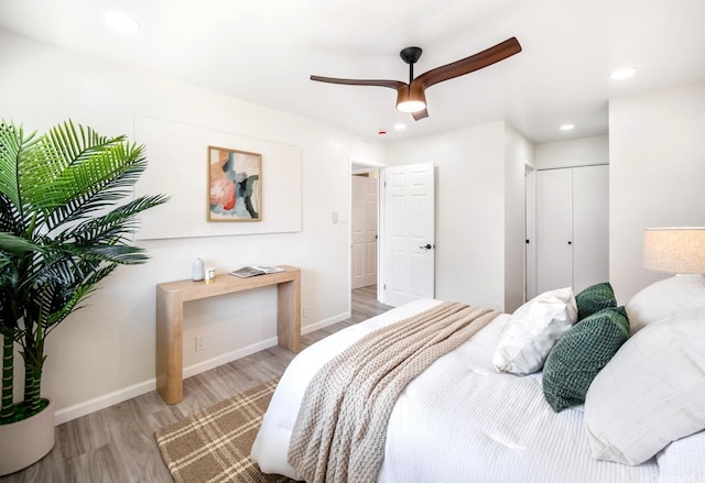 bedroom featuring a closet, wood finished floors, recessed lighting, a ceiling fan, and baseboards