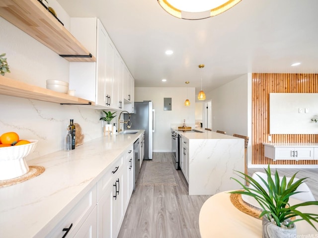 kitchen with light wood finished floors, a sink, open shelves, white cabinets, and appliances with stainless steel finishes
