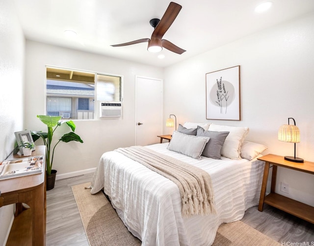 bedroom featuring a ceiling fan, recessed lighting, baseboards, cooling unit, and light wood-type flooring