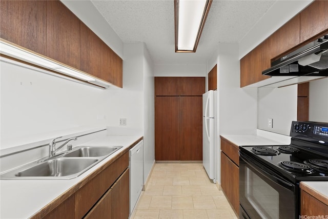 kitchen with a textured ceiling, a sink, light countertops, under cabinet range hood, and white appliances