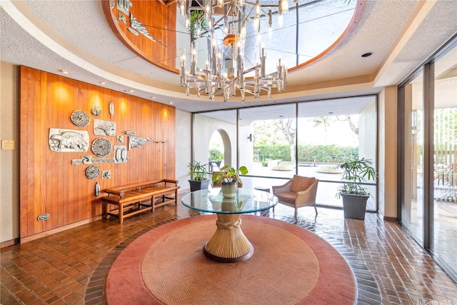 581 Kamoku St Unit Ph4, Honolulu, HI 96826 - dining area featuring brick flooring, wooden walls, baseboards, and a chandelier