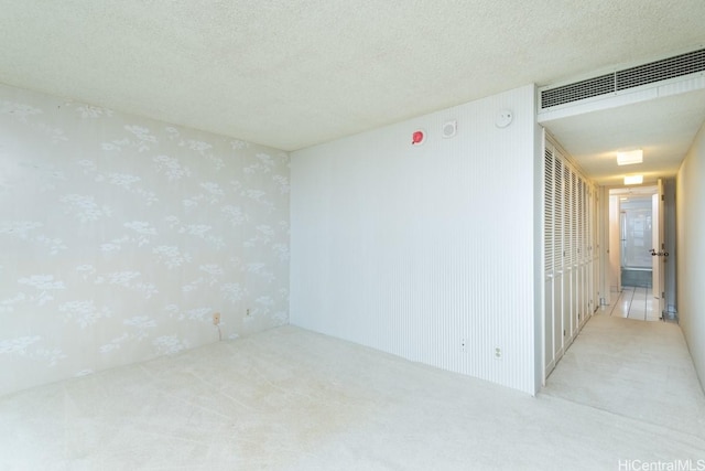 1600 Ala Moana Blvd Unit 1406, Honolulu, HI 96815 - empty room featuring carpet flooring, a textured ceiling, wallpapered walls, and visible vents