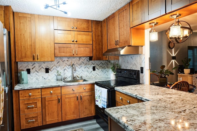 kitchen featuring a sink, light stone counters, under cabinet range hood, and black appliances