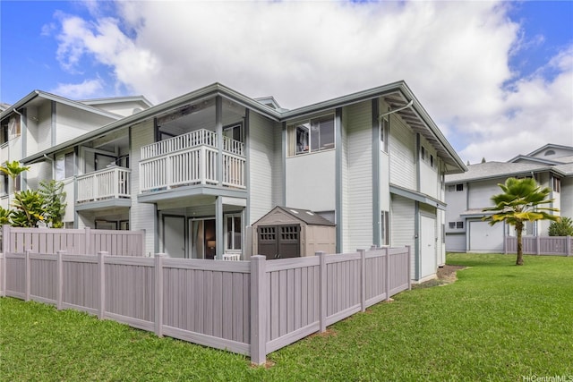 95-781 Wikao St Unit A101, Mililani, HI 96789 - back of house featuring a garage, fence, a balcony, and a lawn