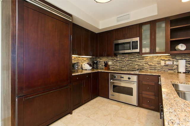 kitchen featuring light tile patterned floors, tasteful backsplash, visible vents, light stone counters, and appliances with stainless steel finishes