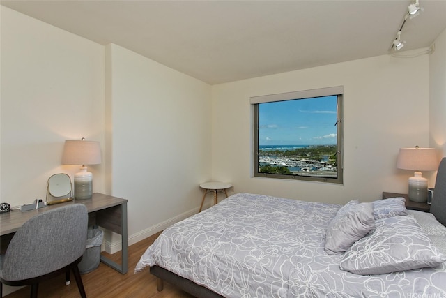 bedroom with wood finished floors and baseboards