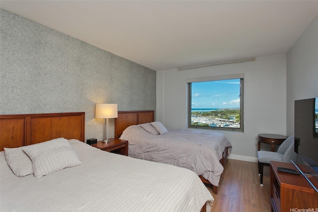 bedroom with wood finished floors and baseboards