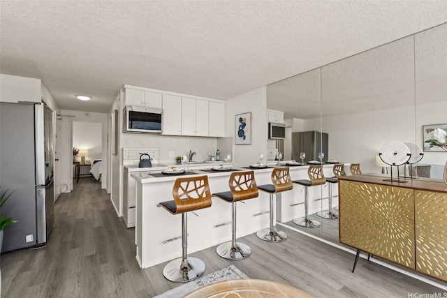 2211 Ala Wai Blvd Unit 2015, Honolulu, HI 96815 - kitchen with a breakfast bar area, stainless steel appliances, and wood finished floors
