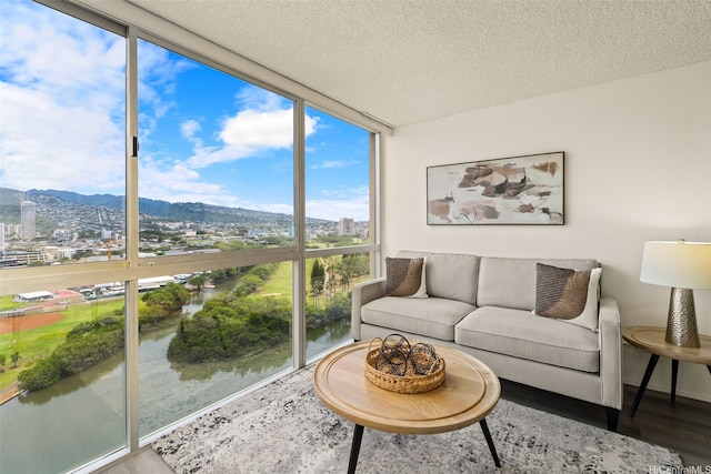 2211 Ala Wai Blvd Unit 2015, Honolulu, HI 96815 - living room featuring a city view, floor to ceiling windows, a textured ceiling, and wood finished floors