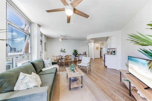 1031 Maunaihi Pl Unit 802, Honolulu, HI 96822 - living room featuring ceiling fan, plenty of natural light, light wood-type flooring, and a textured ceiling