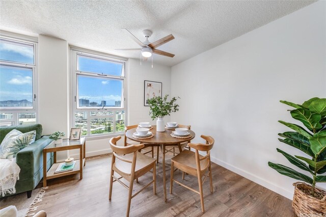 1031 Maunaihi Pl Unit 802, Honolulu, HI 96822 - dining space featuring wood finished floors, a textured ceiling, ceiling fan, and baseboards