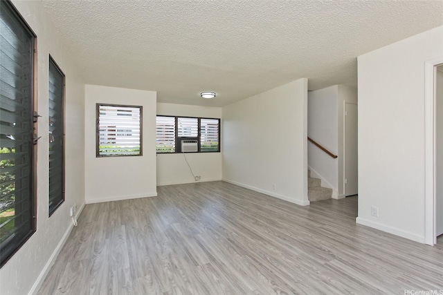 98-376 Kaonohi St Unit 3, Aiea, HI 96701 - spare room featuring stairs, a textured ceiling, baseboards, and light wood finished floors