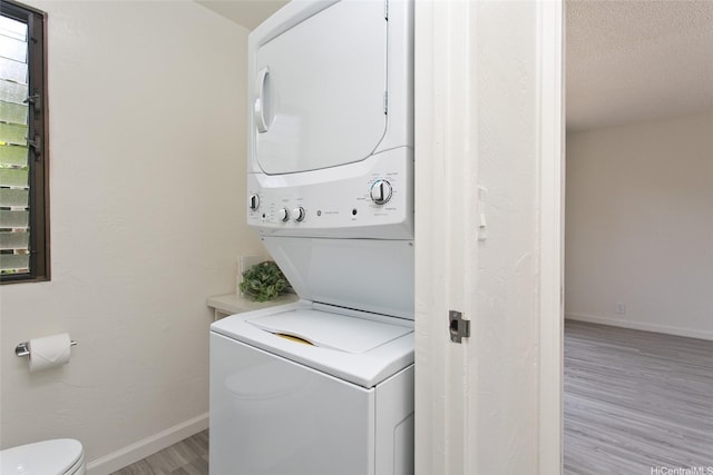 98-376 Kaonohi St Unit 3, Aiea, HI 96701 - laundry area with a textured ceiling, baseboards, stacked washer / dryer, and light wood-type flooring
