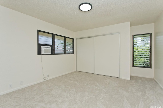 98-376 Kaonohi St Unit 3, Aiea, HI 96701 - unfurnished bedroom with light colored carpet, cooling unit, a textured ceiling, baseboards, and a closet