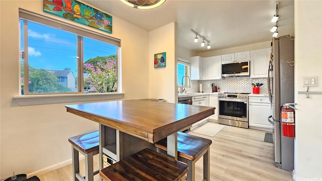 92-1145 Panana St Unit 1608, Kapolei, HI 96707 - kitchen with white cabinetry, appliances with stainless steel finishes, decorative backsplash, and light wood-style flooring
