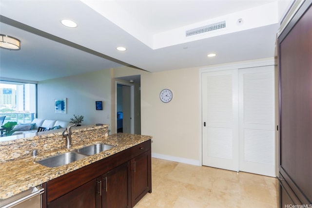 1551 Ala Wai Blvd Unit 703, Honolulu, HI 96815 - kitchen with visible vents, a sink, light stone counters, open floor plan, and paneled fridge