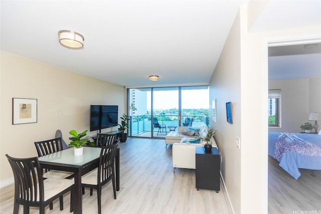 1551 Ala Wai Blvd Unit 703, Honolulu, HI 96815 - dining space with baseboards, a wall of windows, and light wood finished floors