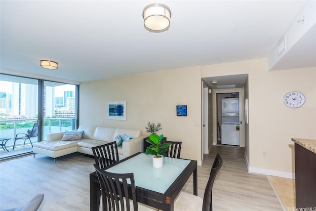 1551 Ala Wai Blvd Unit 703, Honolulu, HI 96815 - dining room with baseboards, stacked washing maching and dryer, a wall of windows, and light wood-style flooring