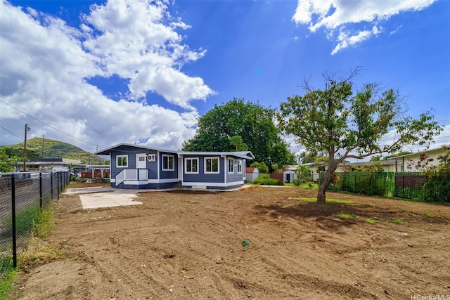 rear view of house featuring fence