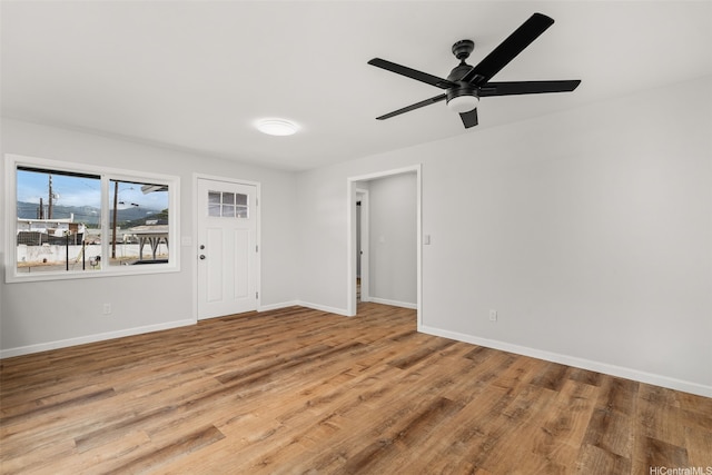 unfurnished living room with baseboards, ceiling fan, and wood finished floors
