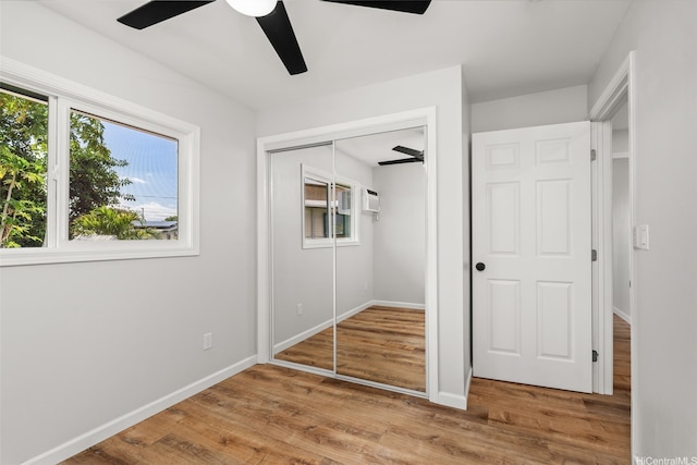 unfurnished bedroom with a ceiling fan, baseboards, wood finished floors, and a closet