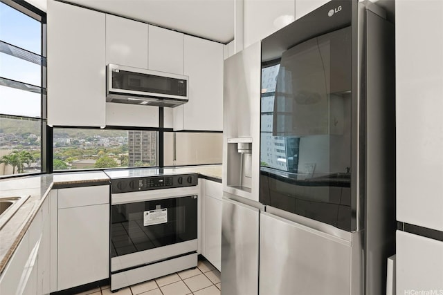 kitchen with white cabinetry, light tile patterned floors, and appliances with stainless steel finishes