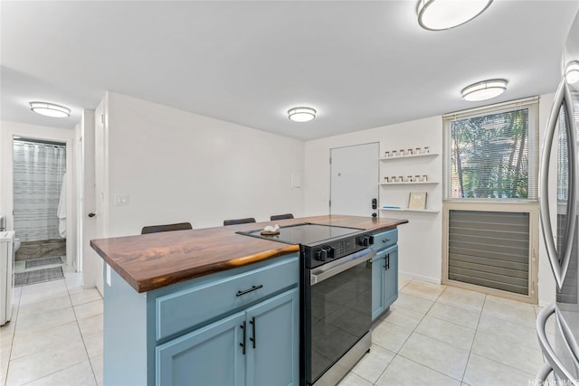 68-090 Au St Unit E102, Waialua, HI 96791 - kitchen with electric range, stainless steel refrigerator, light tile patterned floors, butcher block counters, and blue cabinets