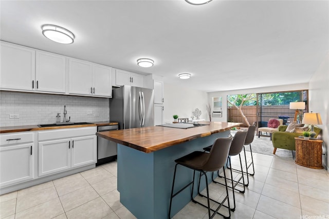 68-090 Au St Unit E102, Waialua, HI 96791 - kitchen with light tile patterned flooring, a sink, stainless steel appliances, backsplash, and butcher block counters