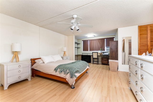 bedroom featuring light wood finished floors, a textured ceiling, and a ceiling fan