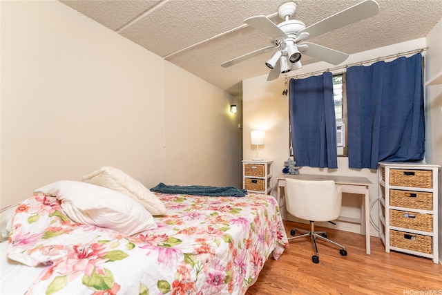 bedroom featuring wood finished floors, ceiling fan, and a textured ceiling