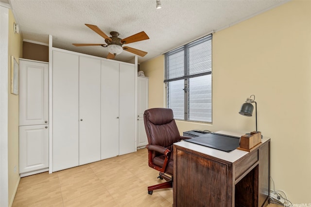 office space featuring a ceiling fan and a textured ceiling