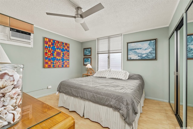 bedroom with a textured ceiling, ceiling fan, baseboards, a closet, and light wood finished floors