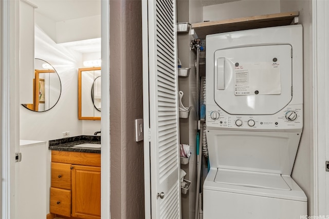 washroom with stacked washer / drying machine, a sink, and laundry area