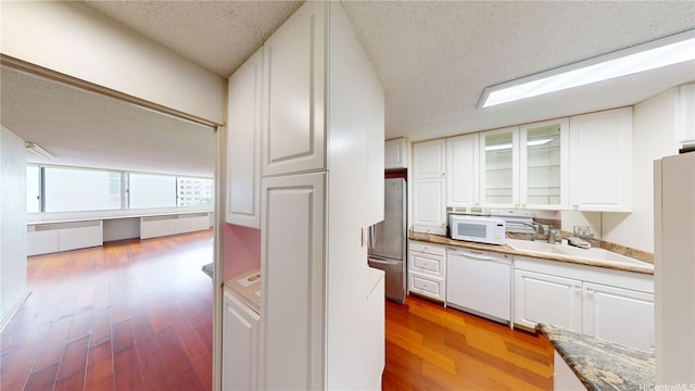 1624 Kanunu St Unit 306, Honolulu, HI 96814 - kitchen with glass insert cabinets, a textured ceiling, white appliances, and white cabinetry