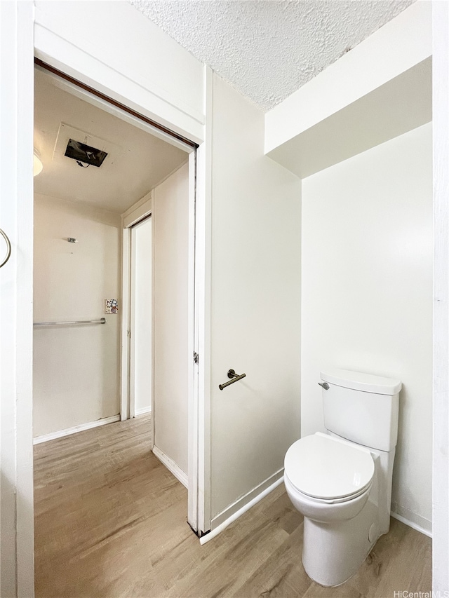 1624 Kanunu St Unit 306, Honolulu, HI 96814 - bathroom with baseboards, a textured ceiling, wood finished floors, and toilet