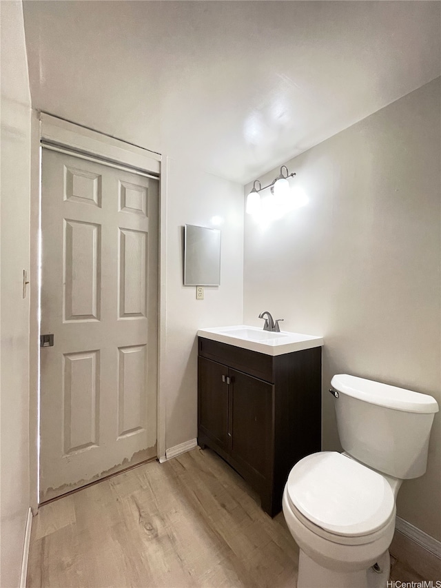 1624 Kanunu St Unit 306, Honolulu, HI 96814 - bathroom with vanity, baseboards, wood finished floors, and toilet