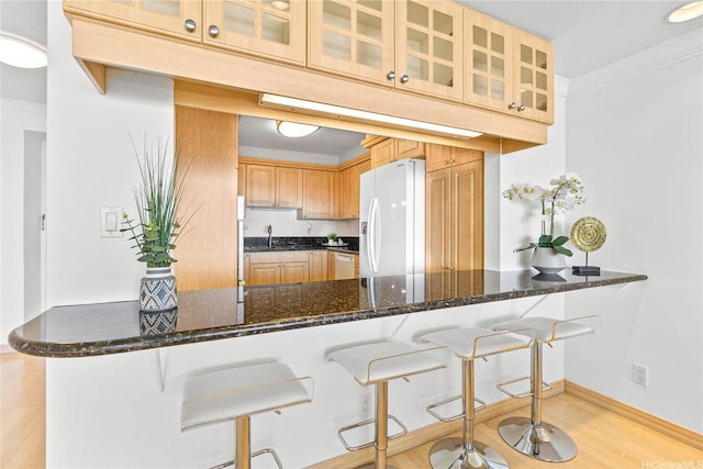1600 Ala Moana Blvd Unit 2406, Honolulu, HI 96815 - kitchen featuring white appliances, a peninsula, a sink, dark stone counters, and glass insert cabinets
