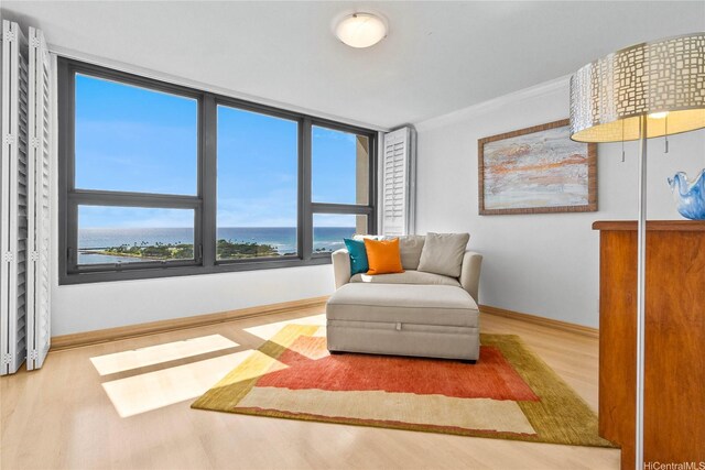 1600 Ala Moana Blvd Unit 2406, Honolulu, HI 96815 - living area with wood finished floors, baseboards, a water view, and ornamental molding