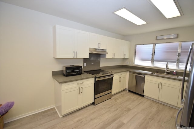 3152 Mokihana Sts, Honolulu, HI 96816 - kitchen with appliances with stainless steel finishes, a sink, under cabinet range hood, light wood-type flooring, and white cabinets