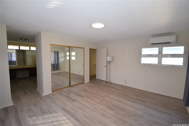 3152 Mokihana Sts, Honolulu, HI 96816 - unfurnished bedroom with a wall mounted AC, multiple windows, light wood-type flooring, and a closet