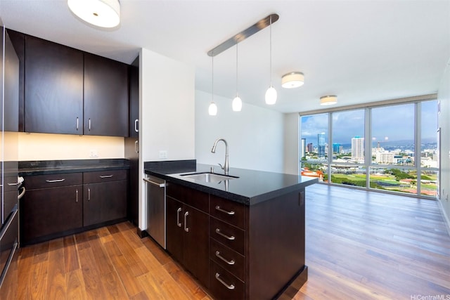 1189 Waimanu St Unit 2308, Honolulu, HI 96814 - kitchen with a sink, dark countertops, a peninsula, and wood finished floors