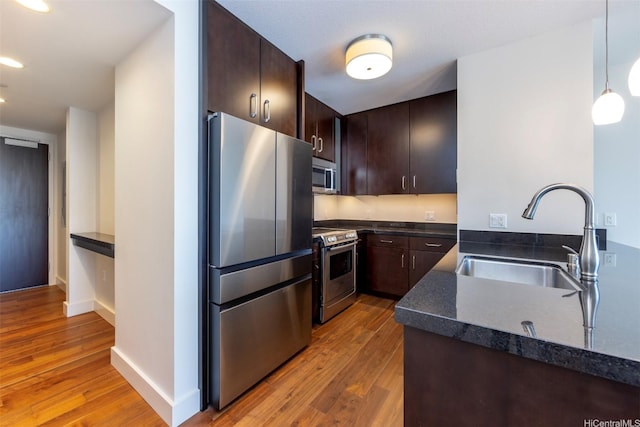 1189 Waimanu St Unit 2308, Honolulu, HI 96814 - kitchen with a sink, wood finished floors, dark countertops, and stainless steel appliances