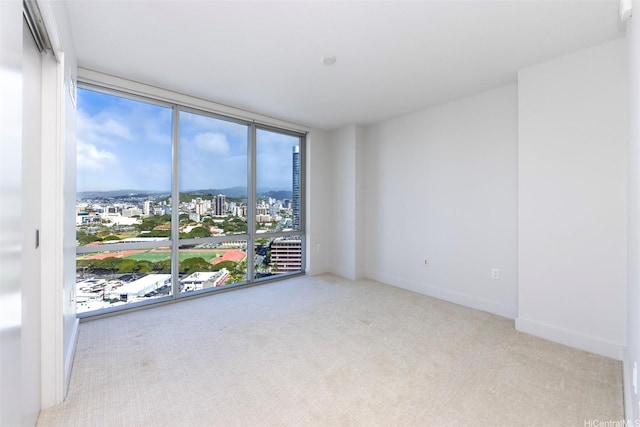 1189 Waimanu St Unit 2308, Honolulu, HI 96814 - carpeted empty room with a wall of windows, a view of city, and baseboards