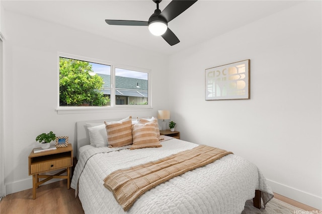 bedroom featuring baseboards, ceiling fan, and wood finished floors