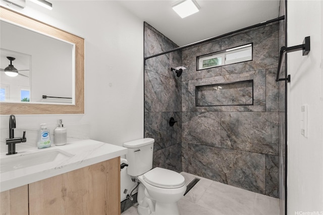 bathroom featuring toilet, ceiling fan, a shower stall, and vanity